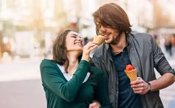 アイスクリームを共有し、笑っている若いカップル