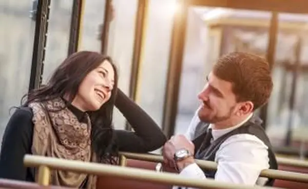 若い男がトラムで女の子に会って話します