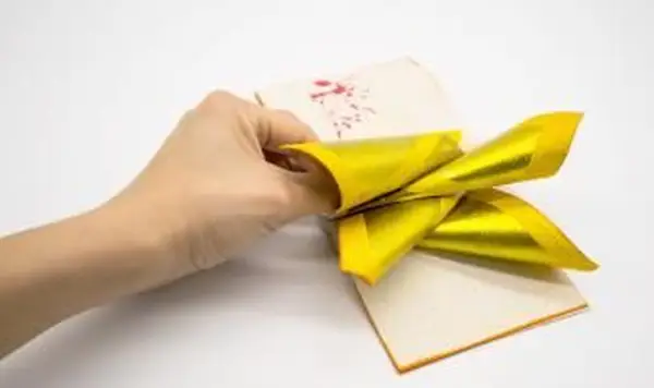 Mão segurando Joss Paper