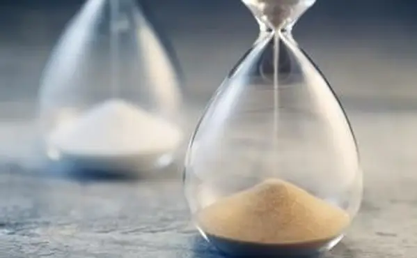 שעון חול זורם על שולחן עץ