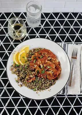 오렌지와 허브 퀴 노아가있는 스모키 콜리 플라워 스테이크