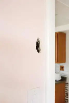 a pink wall with a hole in it