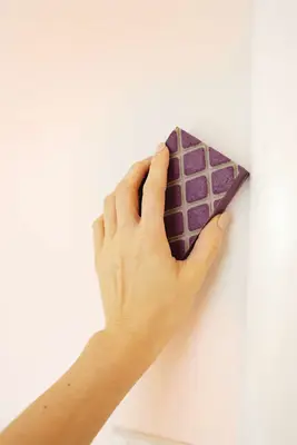 someone sanding the mudded hole in the wall