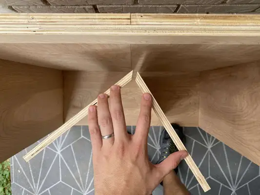 someone framing the roof against the dollhouse