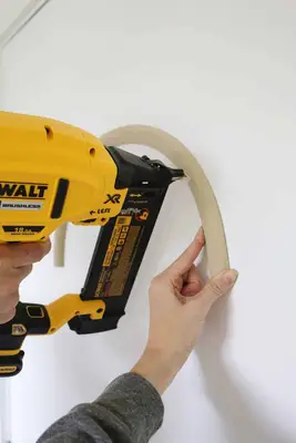 nail gun attaching trim to door