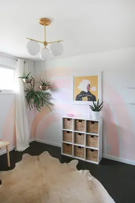 finished rainbow painted on white wall with plants hanging from ceiling and decor around