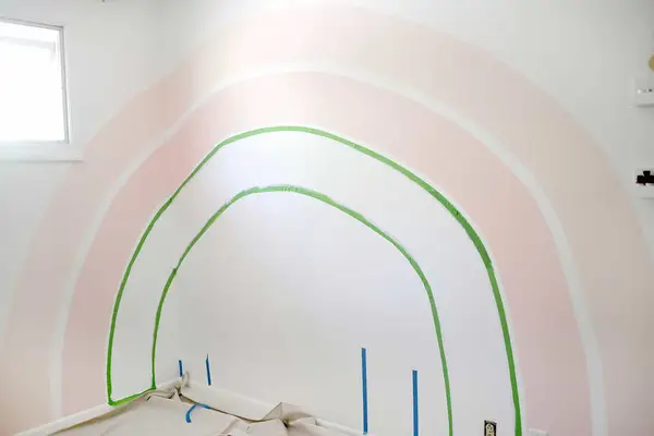 2 pink painted strips of the rainbow on a white wall