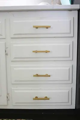 white kitchen drawers with gold handles