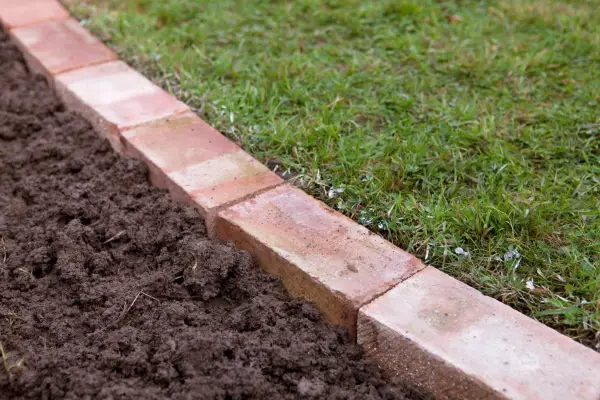 Edging a lawn - soil around the bricks