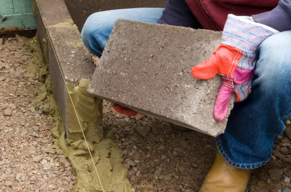 build-a-raised-bed-laying-first-course-of-blocks-2