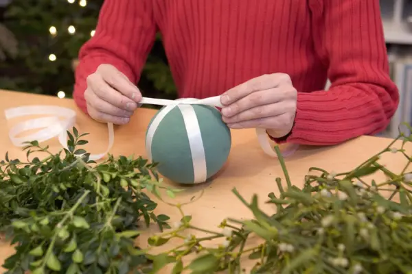 Mistletoe and box Christmas ball - tying ribbon around the sphere