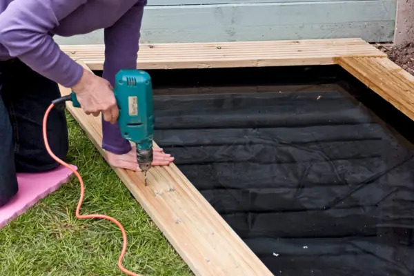 How to build a garden pond - drilling the decking planks in place