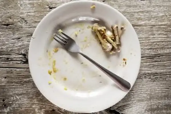 Brudny talerz z resztkami kości z kurczaka