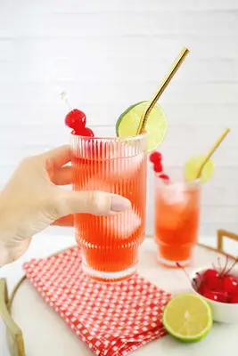 Classic Shirley Temple mocktail with lime wedge and cherry