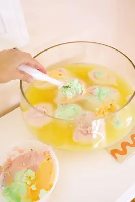 adding scoops of sherbet to rainbow sherbet punch