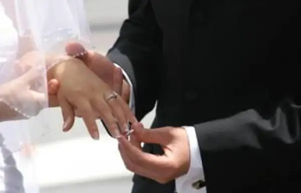 Zakładanie obrączki nad pierścionkiem zaręczynowym podczas ceremonii
