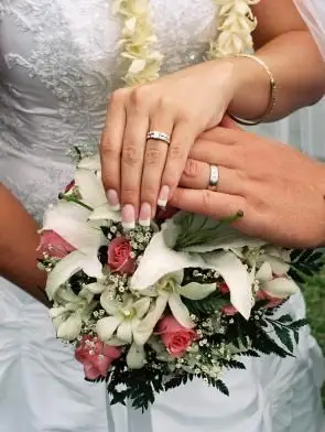 Wyświetlanie obrączek ślubnych nad bukietem ślubnym do zdjęcia