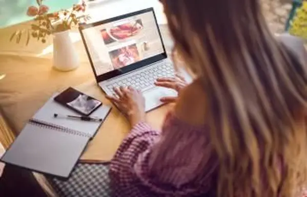 Food blogger femminile che usa il laptop e lavora da casa