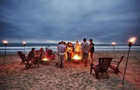 Freunde versammelten sich um Feuer am Strand