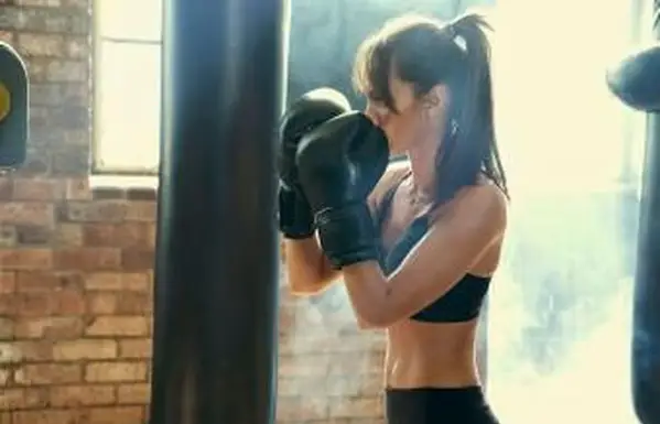 Femme frappant un sac de boxe lourd