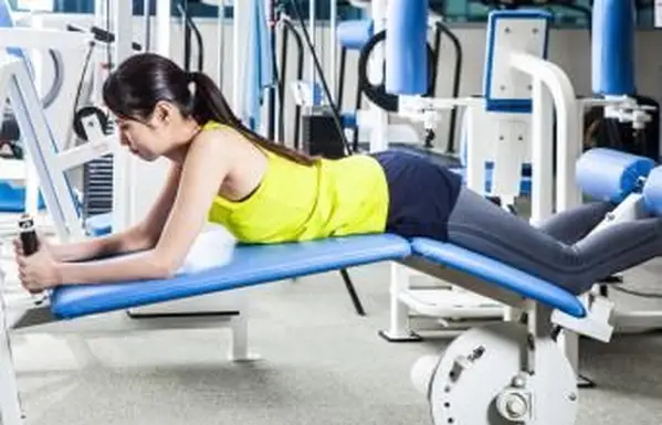 Mulher fazendo flexão de perna na academia