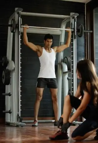 Homem malhando usando Smith Machine