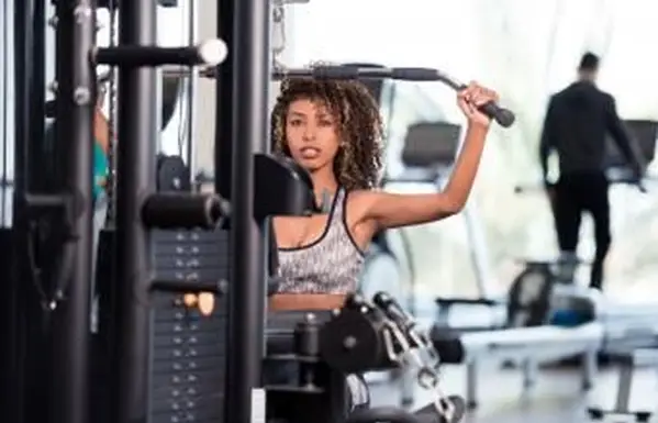 Mulher usando máquina de puxar para baixo