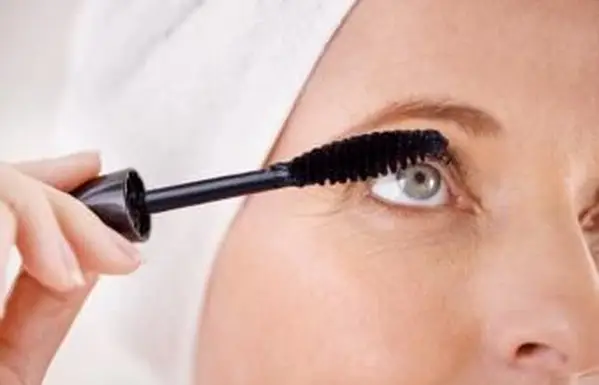 Femme mûre appliquant le mascara