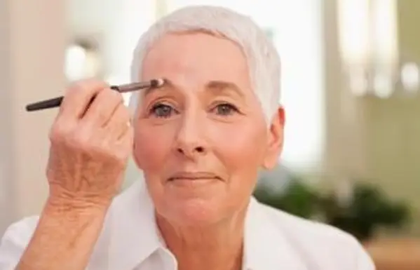 femme appliquant le maquillage des sourcils