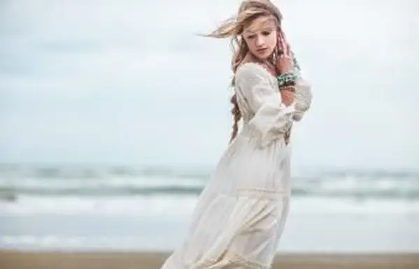 ילדה בוהו בשמלה לבנה על החוף
