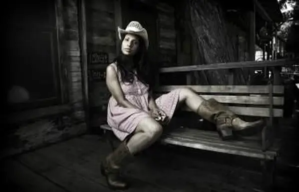 בוקרת בשמלה יושבת במרפסת