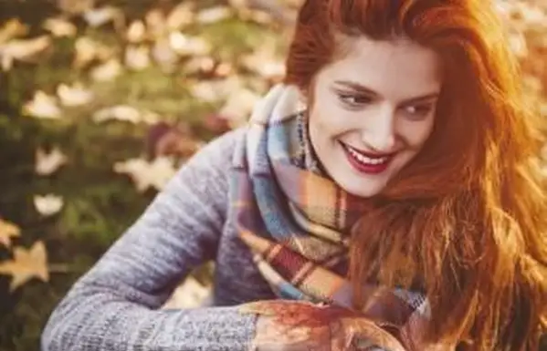 Kobieta w szarym jesiennym swetrze i szaliku