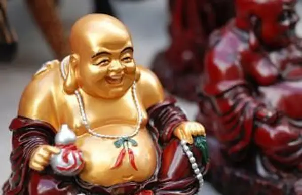 Um Buda dourado a rir com pérolas