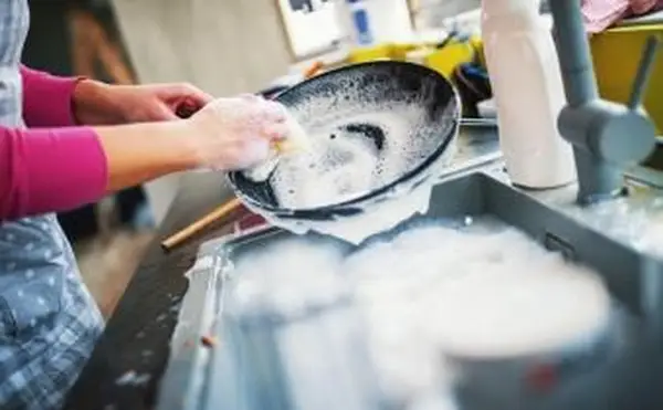 Frau beim Geschirrspülen