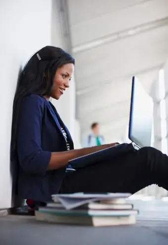 Étudiant utilisant un ordinateur portable sur le sol