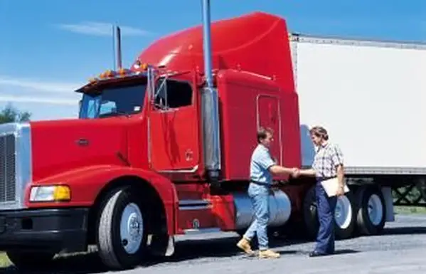 Vodič nákladného vozidla si podáva ruku s klientom