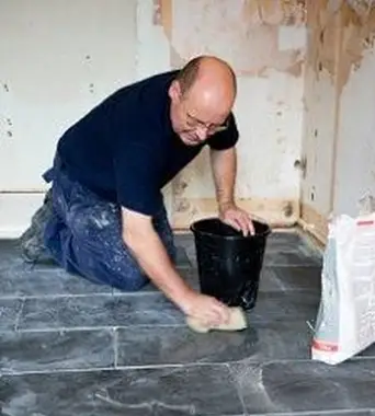 איש שמניח אוטם על רצפות צפחה כדי לשמור על ניקיונם