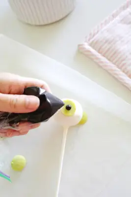 adding a candy pupil to a halloween cake pop eyeball