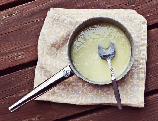 pan with glaze and a spoon in it sitting on a table. 