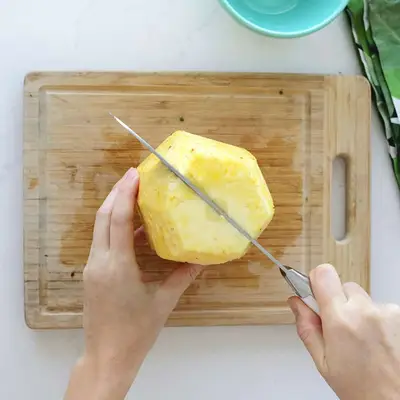 cutting down middle of pineapple