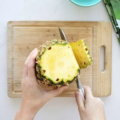 cutting skin off pineapple