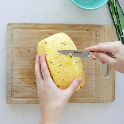 cutting dark spots off pineapple