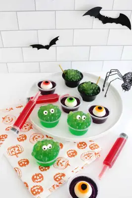easy halloween jello shots that look like monsters, eyeballs, syringes, and witch