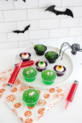 easy halloween jello shots that look like monsters, eyeballs, syringes, and witch
