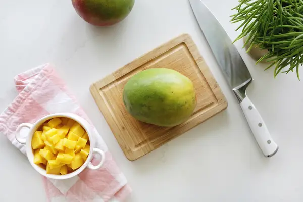 Mango and diced mango on cutting board