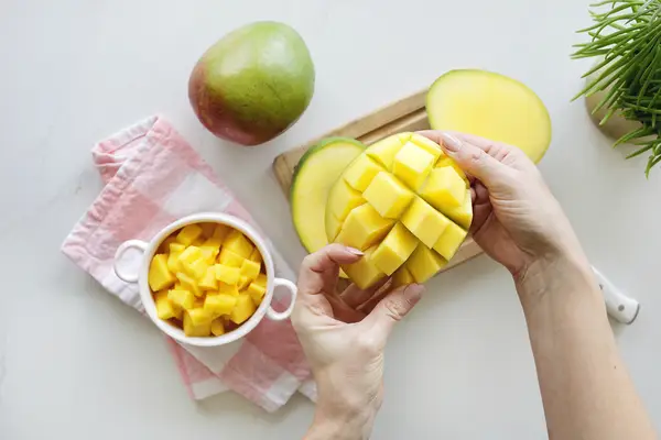 Hand holding half a mango
