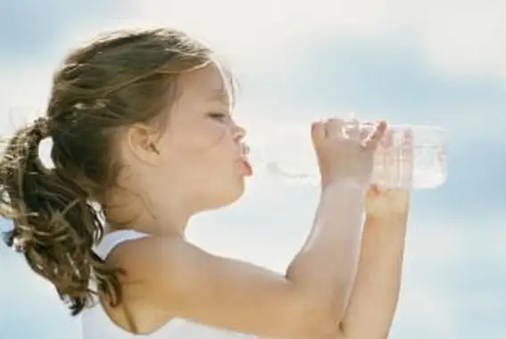 Bambina che beve acqua dalla bottiglia