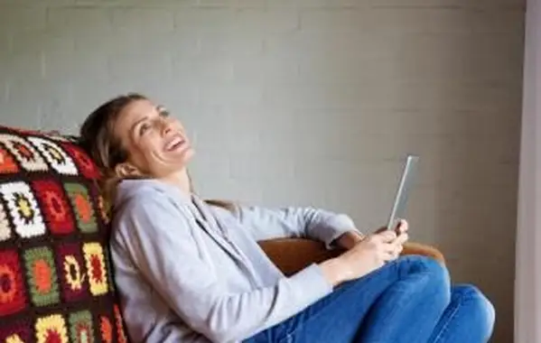 אישה צוחקת על טאבלט