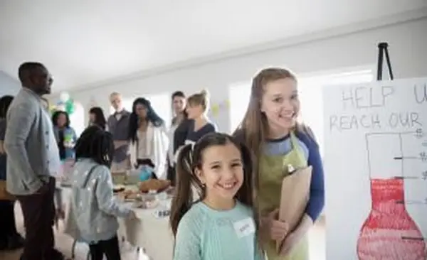 filles debout à la vente de pâtisseries de collecte de fonds
