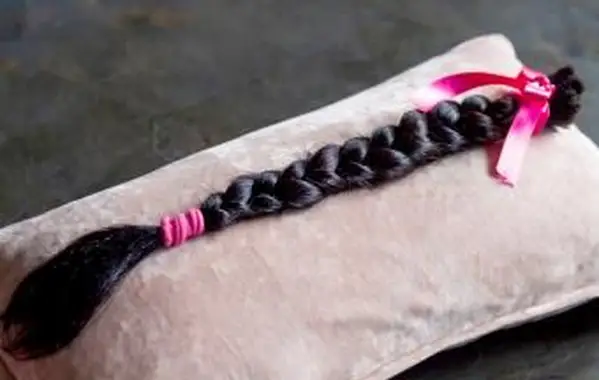 枕に茶色の髪の三つ編みの寄付